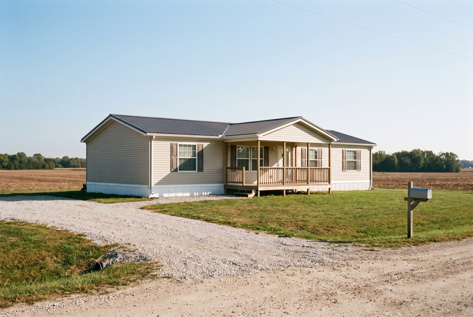 A manufactured home with a covered porch on a rural lot